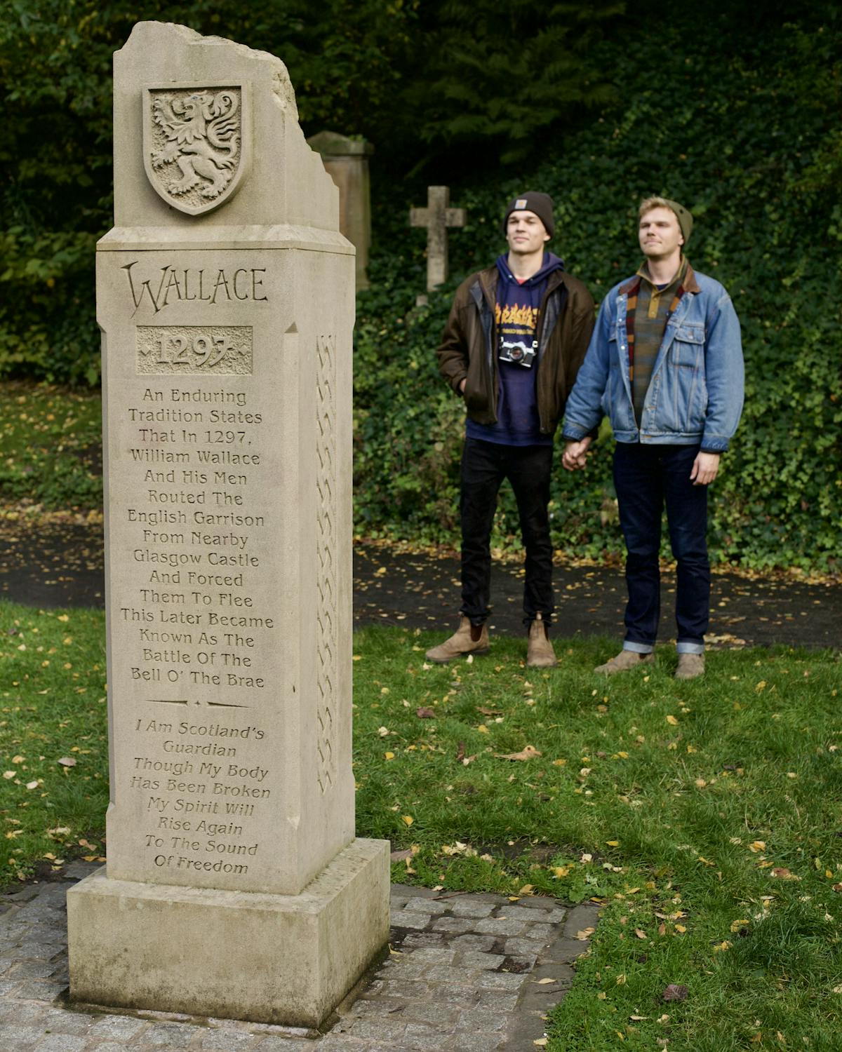 Allister and Jesse standing in front of the William Wallace memorial at the Glasgow Necropolis