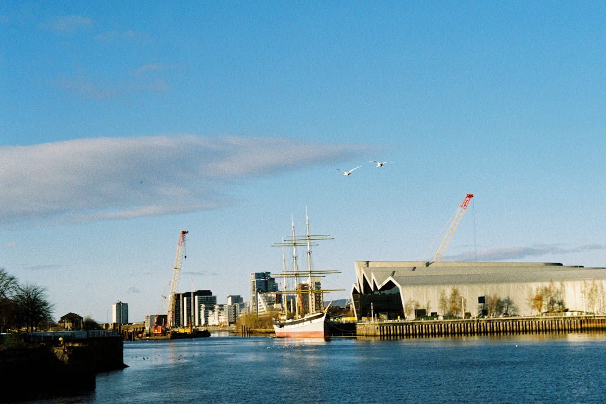 Two swans flying over the River Clyde