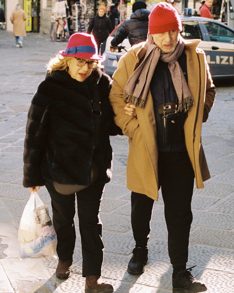 A middle-aged couple wearing bright hats