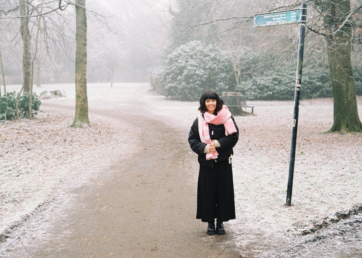 A woman standing in a frost-covered park