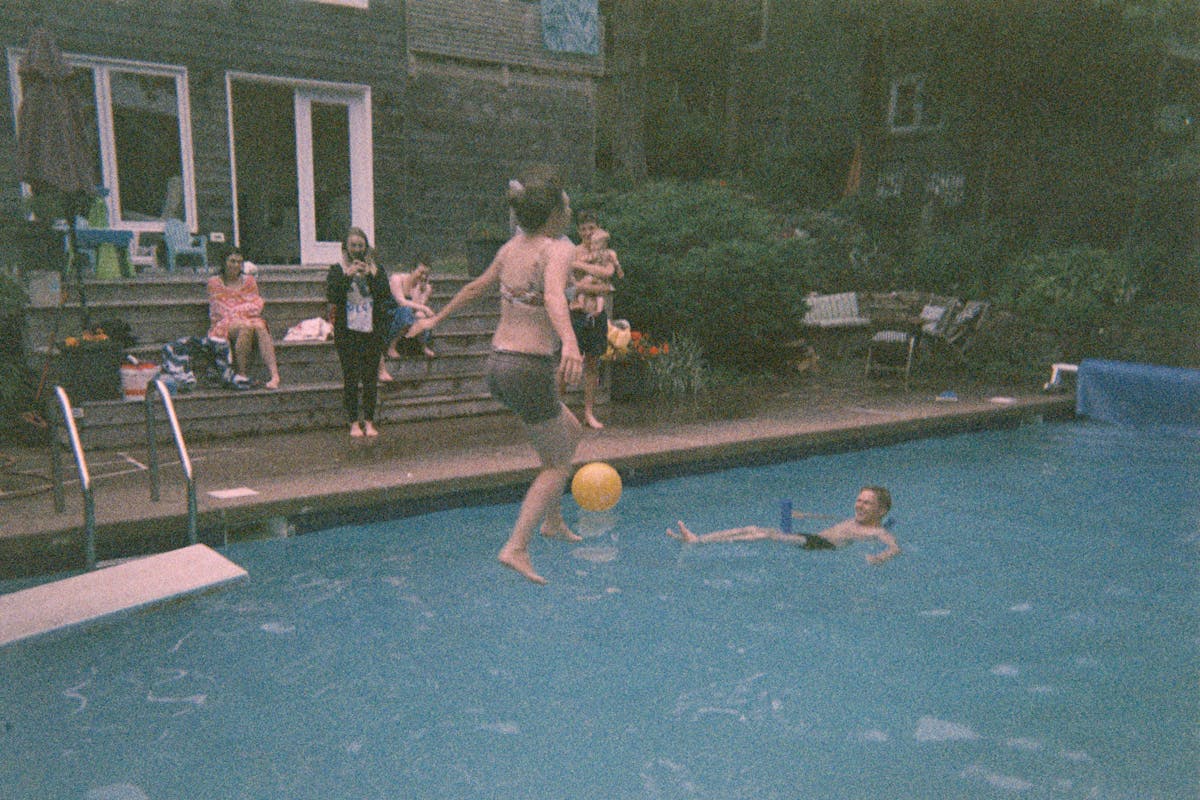 Paige jumping off a diving board, surrounded by my siblings