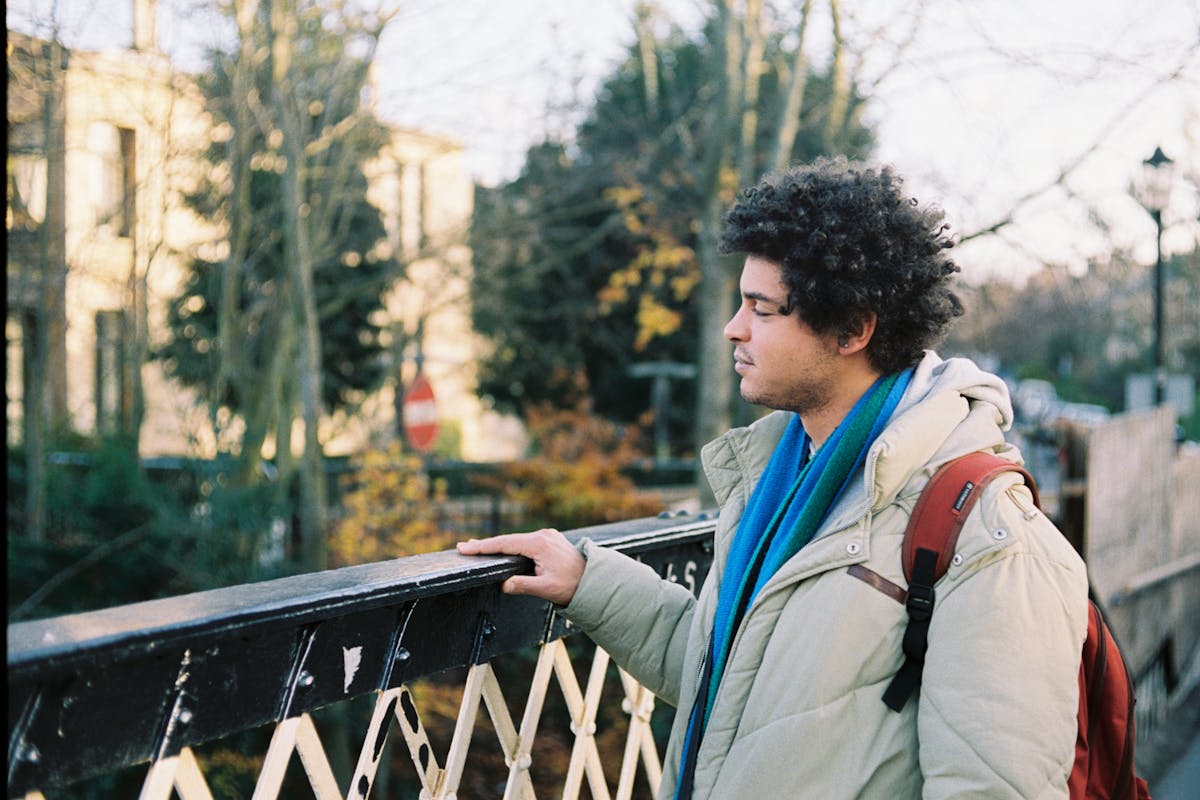 A young man standing on a footbridge