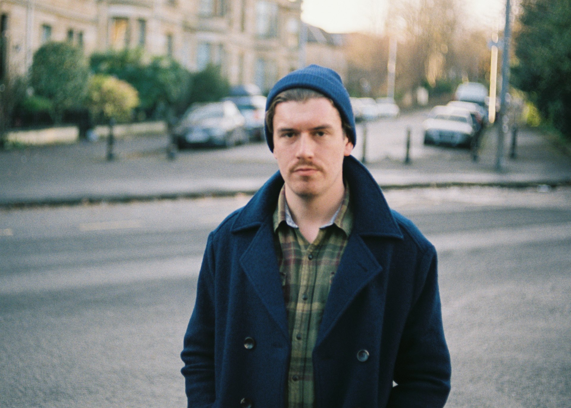 A man in a wool coat standing on the street