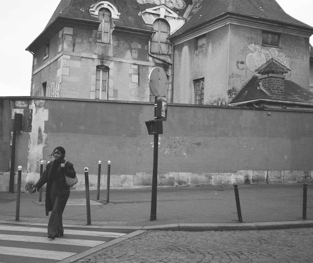 A woman crosses the street at HÃ´pital Saint-Louis