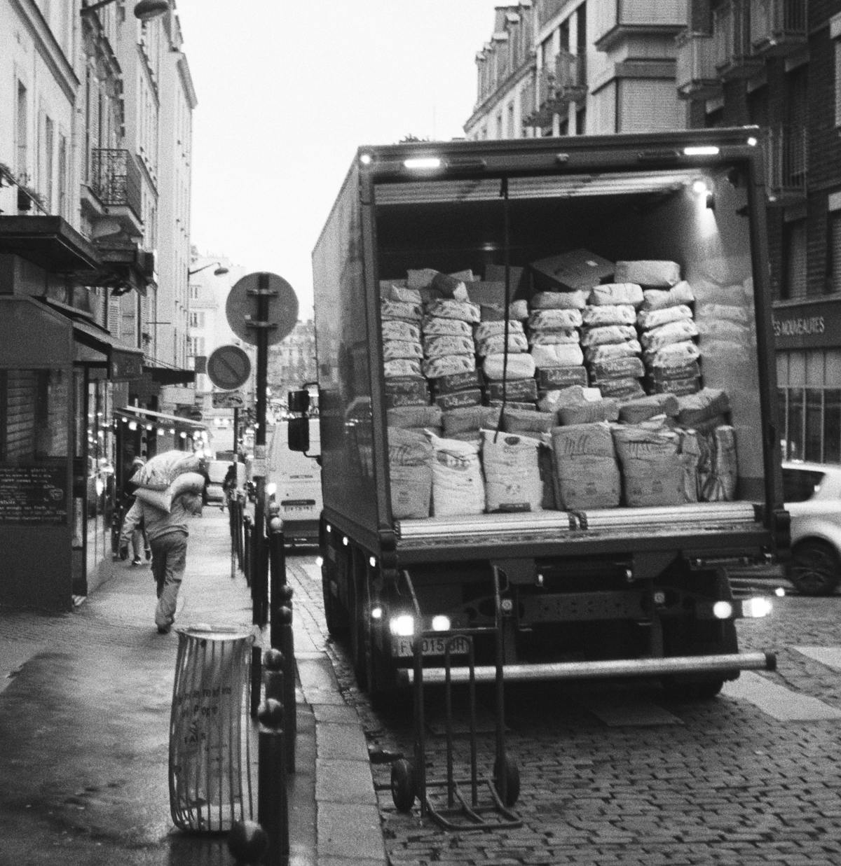 A man unloads flour from a delivery truck