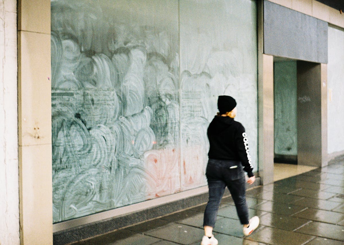 A woman walking past an empty storefront