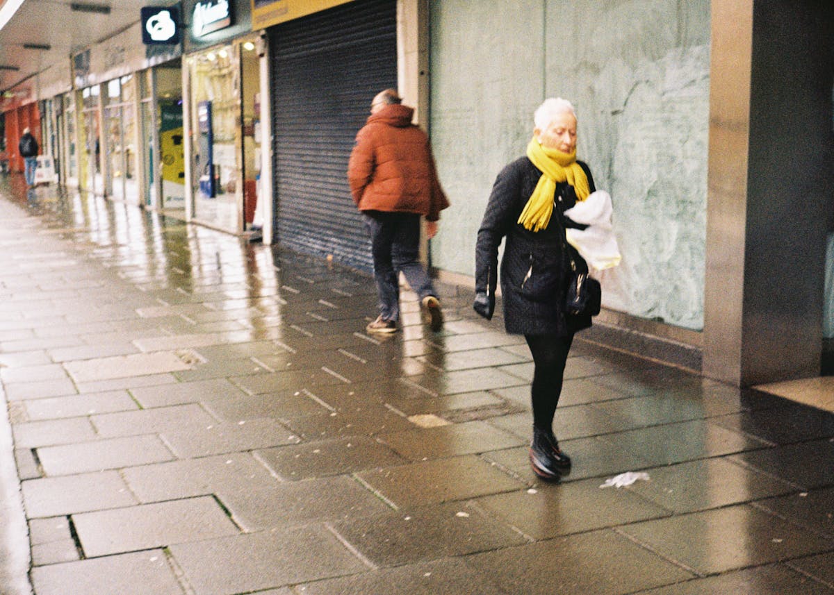 A woman walking past some storefronts