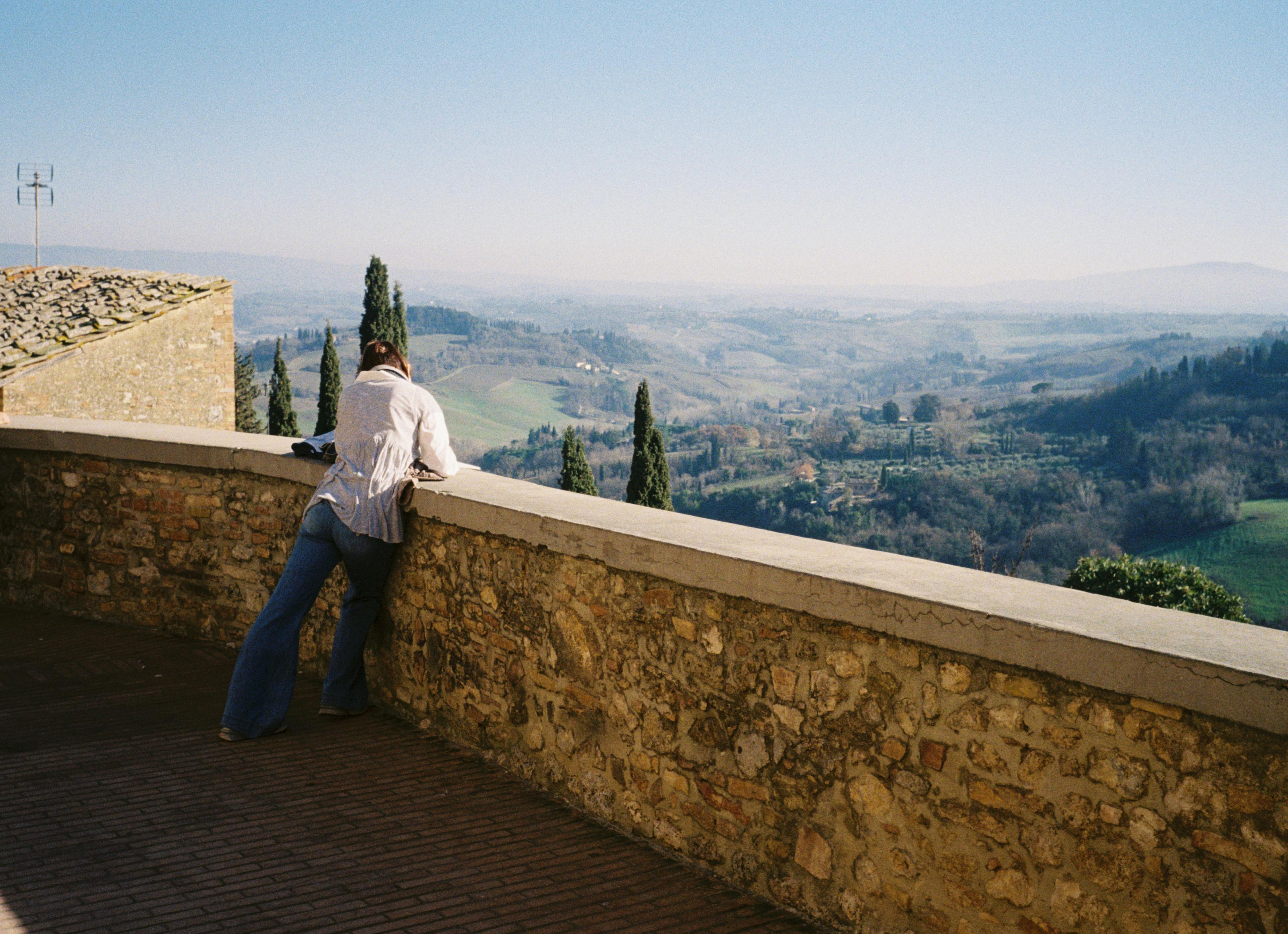A woman sketching in a medieval hill town