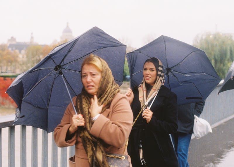 Two women under umbrellas